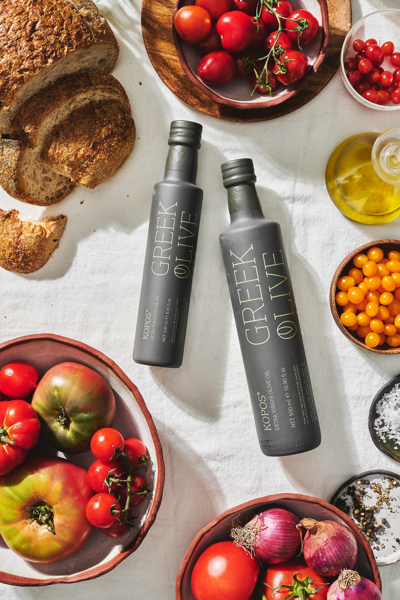Andriotis Greek Olive Oil table with kopos olive oil glass bottles and vegetables