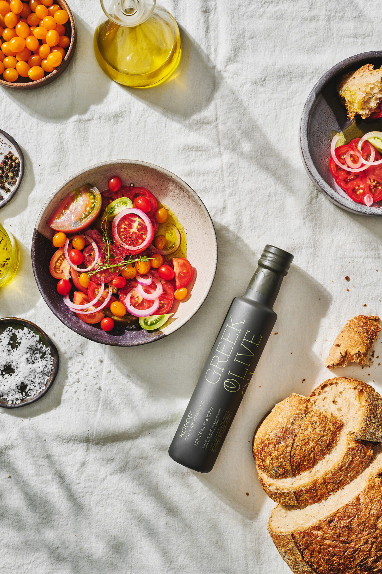 Andriotis Greek Olive Oil table with kopos glass bottle and tomato salad